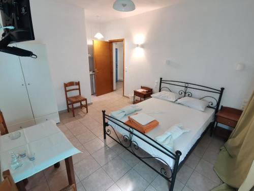 a bedroom with a bed with a table and a desk at Amodari studios on the beach in Plaka