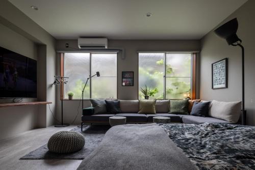 a living room with a couch and a large window at Good Neighbors in Kanazawa