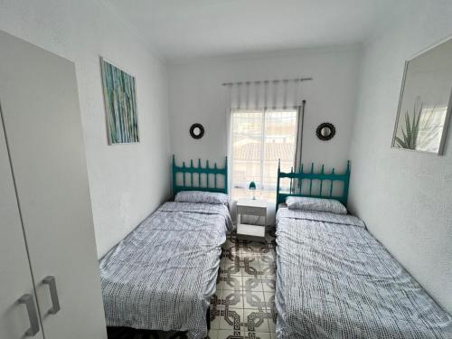 een slaapkamer met 2 bedden en een raam bij Mirror Apartment Gandia in Gandía