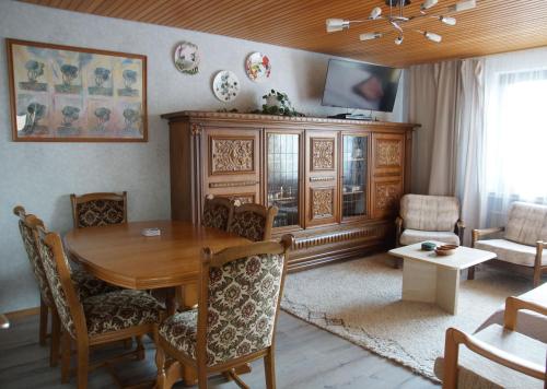 sala de estar con mesa de madera y TV en Haus mit Garten (neben National Park Eifel), en Hürtgenwald