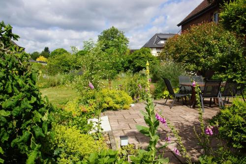 un patio con mesa y sillas en un jardín en Haus mit Garten (neben National Park Eifel), en Hürtgenwald