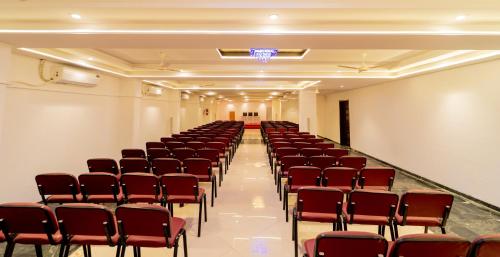 an empty hall with red chairs in a room at Hotel Kewal in Nashik