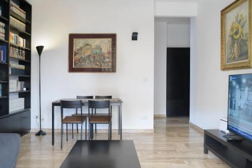 a living room with a table and chairs and a tv at CASA KIKA Comoda, Luminosa e Accogliente in Milan