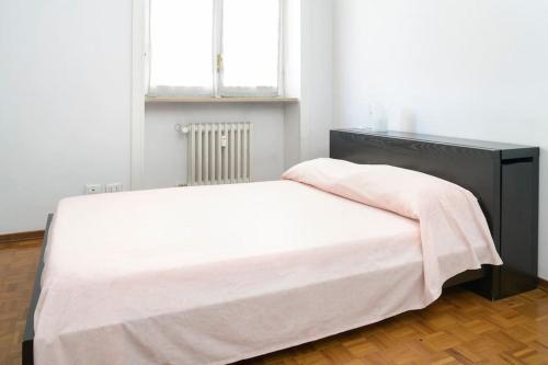 a bedroom with a white bed with a black headboard at CASA KIKA Comoda, Luminosa e Accogliente in Milan