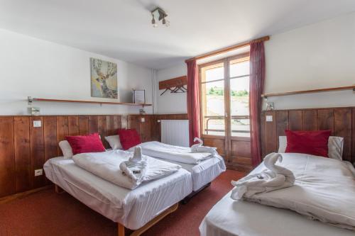 three beds in a room with a window at Hotel Le Refuge in L'Alpe-d'Huez