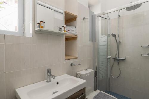 uma casa de banho com um lavatório, um chuveiro e um WC. em Anchorage em Adamas
