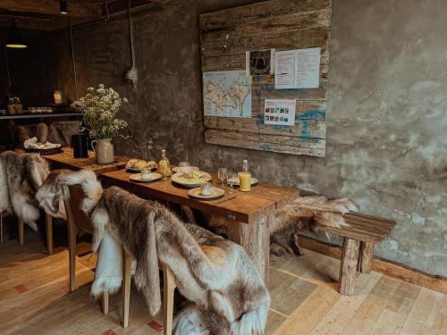 un comedor con una mesa con sillas cubiertas de piel en Naturlig på Korsgården Glamping, en Nysted
