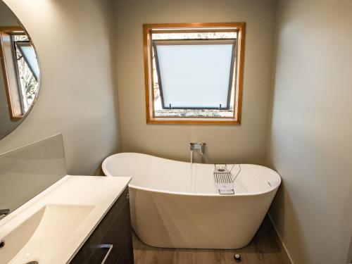 a bath tub in a bathroom with a window at Roydons - Kaiteriteri Upstairs Holiday Unit in Kaiteriteri