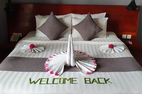 a bed with two pillows and a welcome baby sign on it at Siem Reap Tevi Residence in Siem Reap