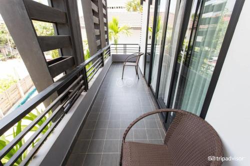a balcony with two chairs and some windows at Siem Reap Tevi Residence in Siem Reap