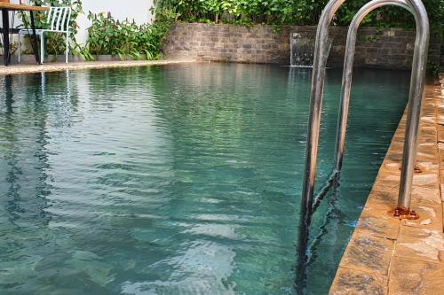 a swimming pool with two faucets in the water at Siem Reap Tevi Residence in Siem Reap