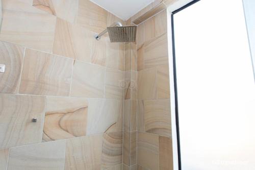 a shower with a glass door in a bathroom at Siem Reap Tevi Residence in Siem Reap
