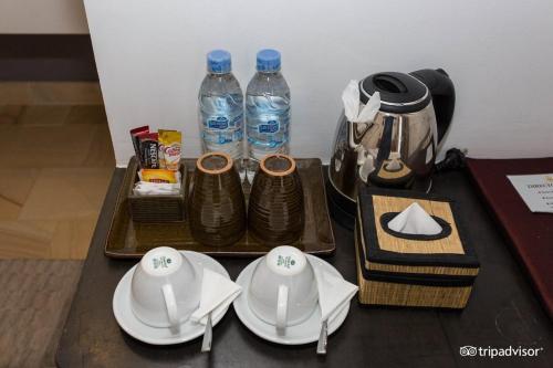 a table with plates and bottles of water on it at Siem Reap Tevi Residence in Siem Reap