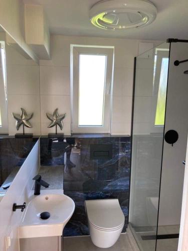 a bathroom with a sink and a toilet and a window at Domki na Horyzoncie - Anna Budny in Trzebusz