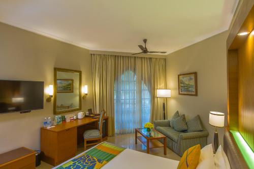 a hotel room with a bed and a desk at Caravela Beach Resort in Varca