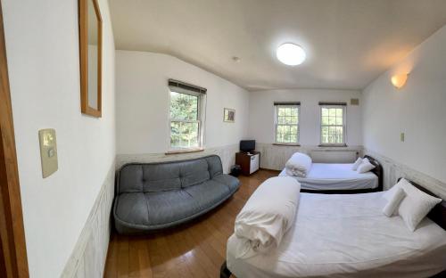 a room with two beds and a couch in it at Chalet Banff - 6 bedroom 6 bathroom Ski Lodge in Niseko