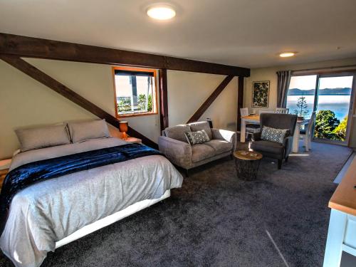 凱特里特里的住宿－Roydon's Flat - Kaiteriteri Downstairs Unit，一间卧室配有一张床、一把椅子和一张桌子