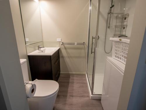 y baño con aseo, lavabo y ducha. en Roydon's Flat - Kaiteriteri Downstairs Unit, en Kaiteriteri
