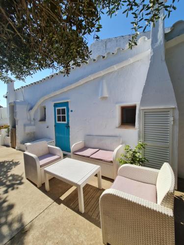 a group of chairs and tables in front of a building at Habitaciones Casa de Campo Daymipaz in Mahón