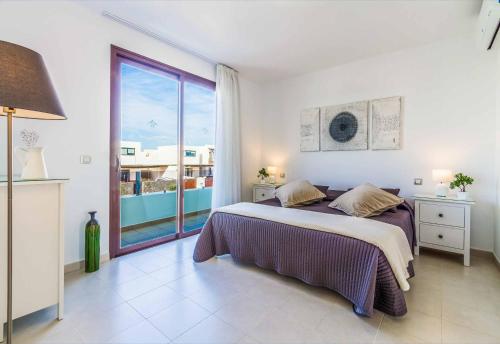 a bedroom with a bed and a large window at Villa Anibal in Playa Blanca