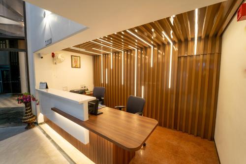 an office with a desk and a wooden wall at Hotel Kewal in Nashik