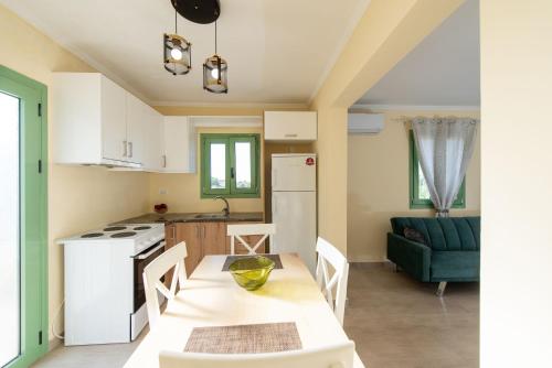 a kitchen and living room with a table and chairs at Mariettas Cottage in Pigadhákia