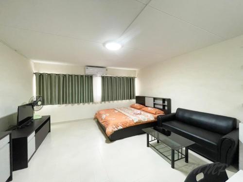 a bedroom with a bed and a couch at ป็อปปูล่าคอนโด เมืองทองธานี ใกล้ Impact 酒店 公寓 in Thung Si Kan