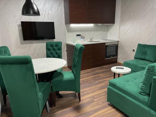 a living room with a table and chairs and a kitchen at Pink House Apartments in Jagodina