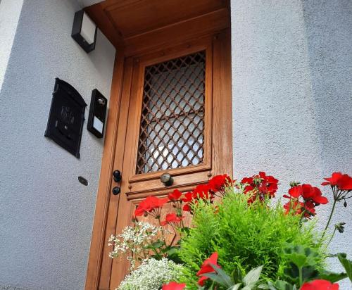 a wooden door with red flowers in front of it at Ferienwohnung Altstadthaus in Oberkirch