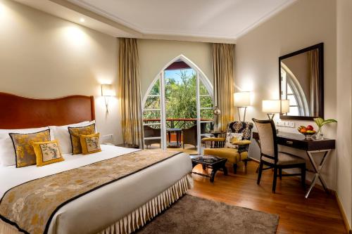 a hotel room with a large bed and a desk at Caravela Beach Resort in Varca