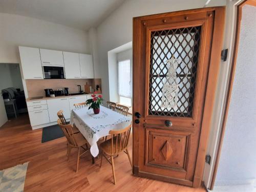 a kitchen and dining room with a table and a door at Ferienwohnung Altstadthaus in Oberkirch
