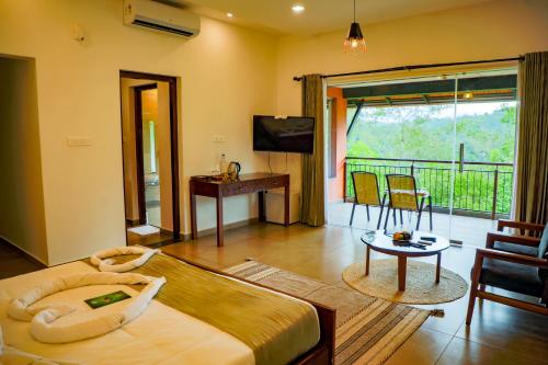 a bedroom with a bed and a table and a balcony at Petals Resorts Wayanad in Tariyod