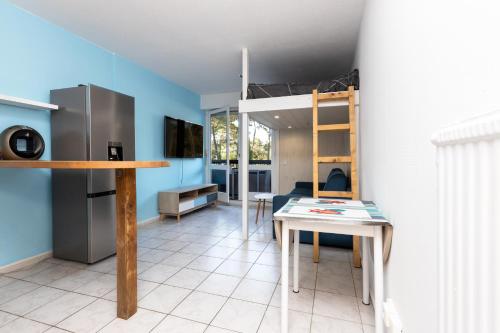 Cette chambre comprend une mezzanine et une table. dans l'établissement Studio Seignosse proche plage, à Seignosse