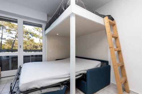 a bedroom with a bunk bed and a ladder at Studio Seignosse proche plage in Seignosse