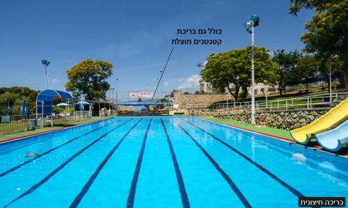 una gran piscina con un tobogán en un parque en לילה בחוף אכזיב en Gesher HaZiw