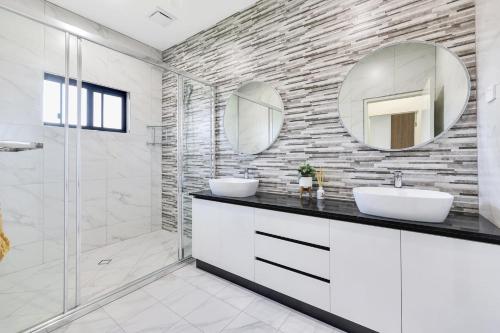 a bathroom with a sink and a mirror at Ravi’s Home in Berrimah