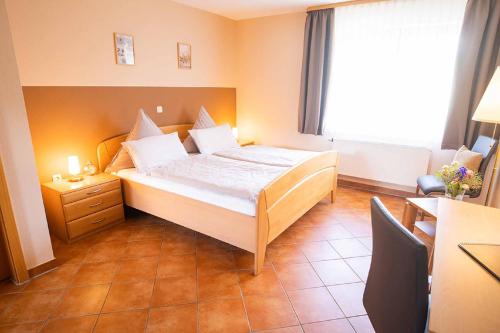 a bedroom with a bed and a desk and a window at Landgasthaus Steffes Hof in Bad Berleburg