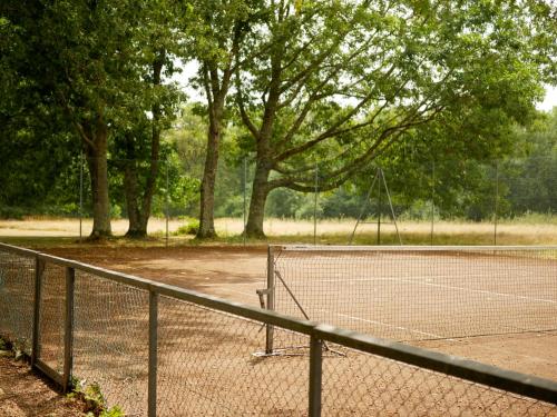 a tennis court with a net and some trees at Best Western Le Bois de la Marche in Poitiers