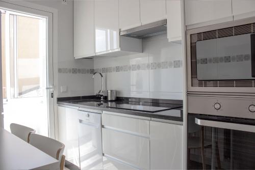 a white kitchen with a sink and a microwave at ROMÁNICO CENTRO in Zamora