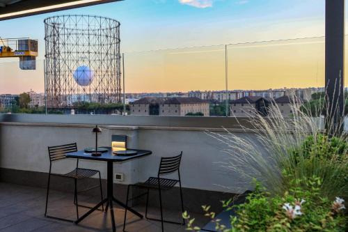a patio with a table and chairs on a balcony at Gasometer Urban Suites in Rome
