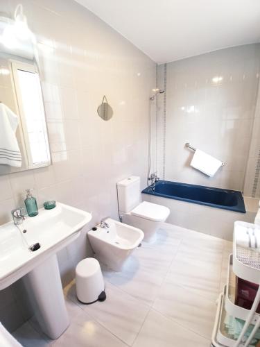 a white bathroom with a sink and a toilet at Sobre la Ría in Viveiro
