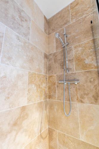 une douche avec un tuyau dans une salle de bain dans l'établissement Studio Elément - Feu, à Saint-Aignan