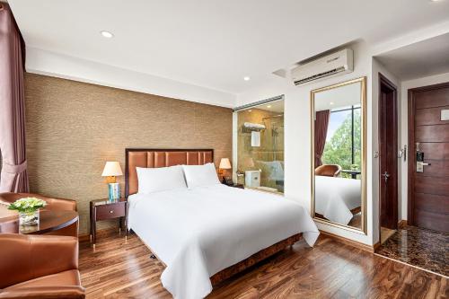 a bedroom with a large white bed and a mirror at Ravatel Home Bac Giang in Bắc Giang