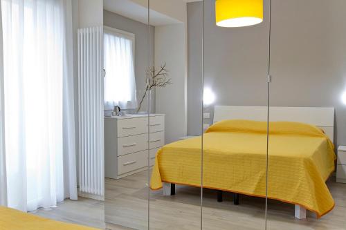 a bedroom with a yellow bed and a glass wall at Residence Armony in Misano Adriatico