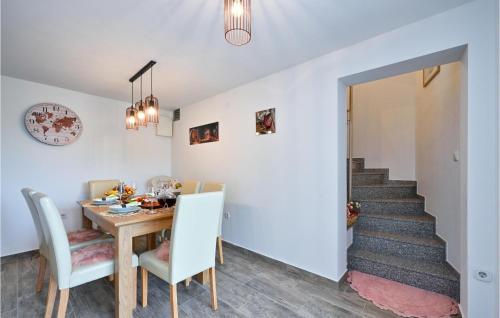 a dining room with a table and chairs and a staircase at Stunning Home In Andrasevec With Sauna in Andraševec