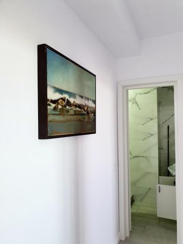 a painting hanging on a wall next to a bathroom at Coral Residence -Mamaia Nord in Mamaia