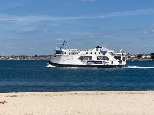 un bateau blanc dans l'eau près d'une plage dans l'établissement LES PAQUERETTES, à Larmor-Plage