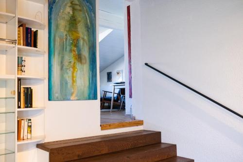 a staircase in a house with a painting on the wall at The Modern & Comfortable Apartment in Ljubljana