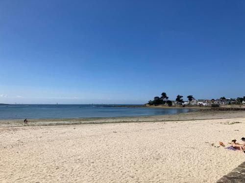 a group of people laying on the beach at LES PAQUERETTES in Larmor-Plage