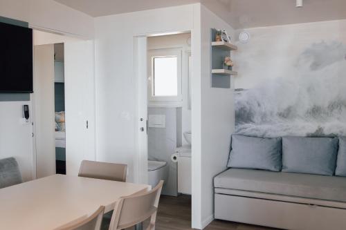 a white dining room with a table and a couch at MOBILE HOMES SELCE - Lighthouse in Selce